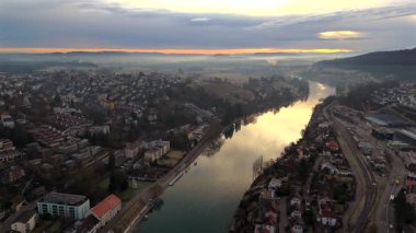 İsviçre 'nin Schaffhausen kentinin havadan görünüşü, Ren Nehri' nin güneşin doğuşuyla birlikte tarihi şehri sarmasıyla çatılar ve altın ışık nefes kesici bir manzara yaratıyor. Luftaufnahme des Rheins in der Schweiz. 