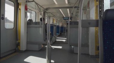 Günümüz S-Bahn tren kompartımanı Münih, Almanya 'da güneşli bir bahar gününde. Mavi koltuklu ve geniş pencereli temiz ve sessiz iç mekan, toplu taşımacılık ve kentsel hareketlilik temasını vurguluyor. 