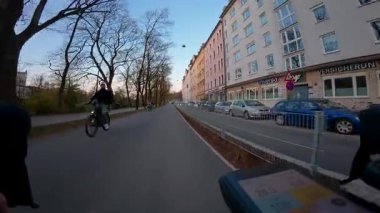 10 Nisan 2025. Münih, Almanya. Bisiklet gidonuna monte edilen kamera Münih akşam caddelerini, bisiklet yolunu, bahar günbatımını, şehir trafiğini ve bisiklet özgürlüğünü yakalıyor. Radweg Muenchen. 