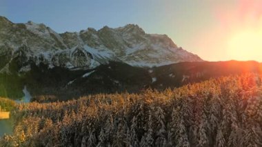 Alman Bavyera Alpleri 'ndeki kar kaplı ağaç tepelerinde nefes kesen hava manzarası, Zugspitze kitsif sergileniyor. Zugspitze Gipfel Wetterstein Dağları 'nın en yüksek zirvesi ve Almanya' nın en yüksek dağı. 