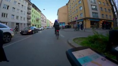 10 Nisan 2025. Münih, Almanya. Bisiklet gidonuna monte edilen kamera Münih akşam caddelerini, bisiklet yolunu, bahar günbatımını, şehir trafiğini ve bisiklet özgürlüğünü yakalıyor. Radweg Muenchen. 