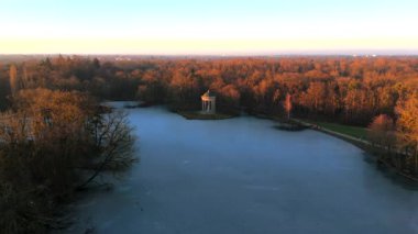 Apollotempel Muenchen im Schlosspark Nymphenburg, Alman Luftbildaufnahme. Almanya 'da Badenburger See ve Apollotempel, sonbaharda Münih hava manzarası gün batımında. Apollotemple Park 'ta Nymphenburg. 