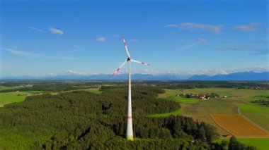 Almanya 'nın Ebersberg bölgesindeki Bavyera' daki rüzgar türbininin hava görüntüsü. Bayern, Deutschland 'deki Luftaufnahme einer Windtürbin vor dem Hintergrund der Alpen. Alplere bakan golf sahasında rüzgar türbini. 
