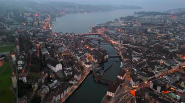 Stadtbild von Luzern Luftaufnahme, Schweiz bei Nacht mit Stadtlichtern, nebligem Wetter. Luftbild vom Fluss Reuss und allen bekannten Bruecken am Abend. Gece Lucerne şehir merkezinin havadan görünüşü