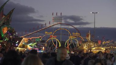 2 Ekim 2024. Münih, Almanya. Olympia döngüsü. Fuenfer-Looping, Achterbahn der Welt am Abend mit Lichtern auf dem Oktoberfest Muenchen, Deutschland 'da. Eğlence parkı. 