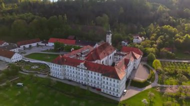 Yukarı Bavyera 'daki Schaeftlarn Abbey ve Praelatengarten parkının insansız hava aracı görüntüleri. Bahçe tasarımı, kırsal alan, yemyeşil tarlalar ve mavi gökyüzü altında kültürel mirası olan tarihi Benedikt manastırı. 