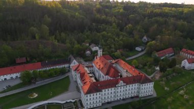 Luftaufnahme des Klosters Schaeftlarn und des barocken Praelatengartens in Oberbayern. Benediktinerabtei tarihsel park, eingebettet in gruene Landschaft dava lich von Muenchen, Deutschland. 