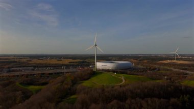 Rüzgâr türbinli Froettmaninger Mullberg 'in hava görüntüsü ve Münih' teki Allianz Arena 'nın net bir görüntüsü. Freimann rüzgar türbini ve Münih futbol arenasının kuş bakışı perspektifi. 