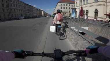 29 Nisan 2025. Münih, Almanya. Münih şehir merkezindeki bisikletli POV. Bisikletçiler bisiklet yolunda, modern şehir hareketliliğini, trafiği ve sağlıklı, yeşil ulaşım çözümlerini gösteriyor.