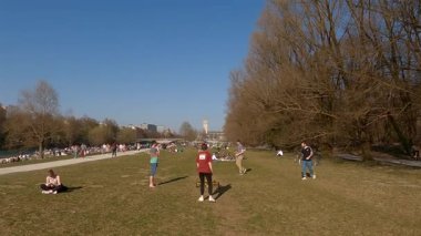 27 Nisan 2022. Münih, Almanya. İzleyiciler St. Maximilian Kilisesi 'nin yakınlarındaki ilk sıcak günlerin tadını çıkarıyorlar. Bisikletçiler, aileler ve arkadaşlarla Münih' in yeşil kalbinde güneşleniyorlar.. 