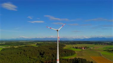 Almanya 'nın Ebersberg bölgesindeki Bavyera' daki rüzgar türbininin hava görüntüsü. Bayern, Deutschland 'deki Luftaufnahme einer Windtürbin vor dem Hintergrund der Alpen. Alplere bakan golf sahasında rüzgar türbini. 