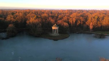 Apollotempel Muenchen im Schlosspark Nymphenburg, Alman Luftbildaufnahme. Almanya 'da Badenburger See ve Apollotempel, sonbaharda Münih hava manzarası gün batımında. Apollotemple Park 'ta Nymphenburg. 