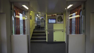 Üst kata çıkan merdivenleri olan modern İsviçre çift katlı trenin iç kısmı. Dijital ekranları, tırabzanları ve kapıları olan temiz, parlak bir tasarım. Rahat toplu taşıma, seyahat ve günlük seyahat