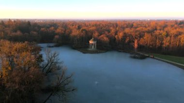 Apollotempel Muenchen im Schlosspark Nymphenburg, Alman Luftbildaufnahme. Almanya 'da Badenburger See ve Apollotempel, sonbaharda Münih hava manzarası gün batımında. Apollotemple Park 'ta Nymphenburg. 