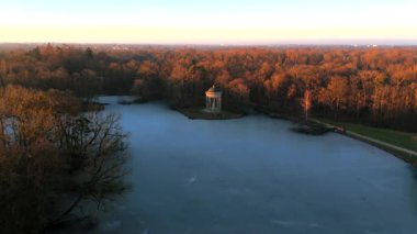 Apollotempel Muenchen im Schlosspark Nymphenburg, Alman Luftbildaufnahme. Almanya 'da Badenburger See ve Apollotempel, sonbaharda Münih hava manzarası gün batımında. Apollotemple Park 'ta Nymphenburg. 