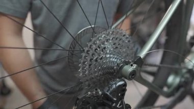 Bisikletli tamirci atölyede çalışıyor. Velomekanik tamir istasyonunda fren mekanizmasını tamir eder ve ayarlar. Bisikletçi teknisyeni çakıl bisikletinin arka hidrolik frenini ayarlıyor.. 