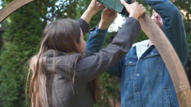 Erkek ve kadın, küçük işletme düğün dekoratörleri, açık hava bahçe töreni için ahşap bir çiçek kemeri kurun. Birlikte çalışıyorlar, güzel bir ortam yaratmak için detaylara çok dikkat ediyorlar.. 