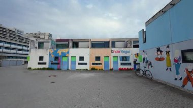 13 Nisan 2025 Münih, Almanya. Almanya 'nın Münih Olimpiyat Köyü' nde renkli öğrenci bungalovları canlı mimari manzara içinde kentsel yaşam, gençlik kültürü ve Olimpiyat tarihini harmanlıyor. Olydorf. 