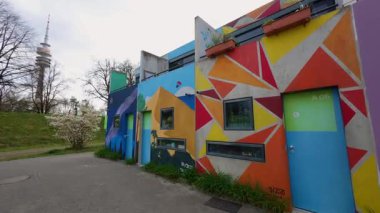 13 Nisan 2025 Münih, Almanya. Almanya 'nın Münih Olimpiyat Köyü' nde renkli öğrenci bungalovları canlı mimari manzara içinde kentsel yaşam, gençlik kültürü ve Olimpiyat tarihini harmanlıyor. Olydorf. 