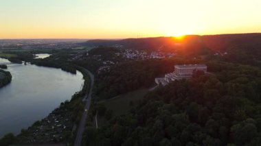 Donaustauf, Bavyera 'da gün batımında Walhalla. Drone görüntüleri, Almanya 'nın Regensburg yakınlarındaki tepelerin üzerinden panoramik manzaralı ve yumuşak akşam ışığında Tuna Nehri üzerindeki mermer tapınağı yakalıyor.