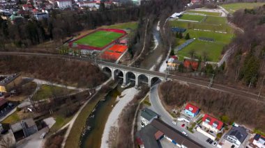 Almanya, Bavyera 'daki tarihi Traunsteiner Viaduct' un hava manzarası. Bu çarpıcı taş demiryolu köprüsü Traun Nehri boyunca uzanır. Parlak, güneşli gökyüzünün altında bereketli bahar manzaralarıyla çevrili.. 