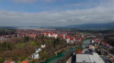 Almanya, Fuessen 'in nefes kesici hava manzarası, St. Mang Kilisesi, görkemli Hohes Schloss ve Lech Nehri' nin sergilenmesi. Büyüleyici ortaçağ kasabası yemyeşil ve Bavyera Alpleriyle çevrili.. 