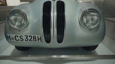 20 Nisan 2022. Münih, Almanya. Ziyaretçiler, Münih 'teki BMW Müzesi' ndeki klasik BMW 328 Touring Coupe 'ye hayranlık duyuyorlar..