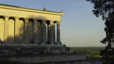 Walhalla manzaralı köşesinden Tuna Nehri 'nin üzerinden güneşin batışını izle. Turistler, Almanya 'nın Regensburg kenti yakınlarındaki bu ikonik Bavyera tarihi ve sakinliğinin tadını çıkarıyorlar. Almanya 'da turizm ve seyahat. 