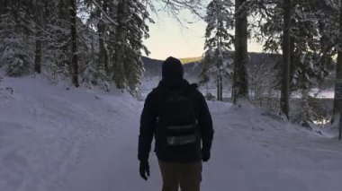 Almanya 'da Garmisch-Partenkirchen yakınlarında Eibsee-Rundweg' de kış yürüyüşü. Karla kaplı patika, orman yürüyüşü, nefes kesici dağ manzarası, sakin atmosfer, macera ve sükunet bir arada. Eibsee döngü izi