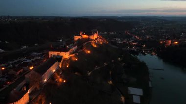 Naechtliche Luftaufnahme der Burg zu Burghausen ist eine Hoehenburgin Bayern, Deutschland, vom Woehrsee aus. Europas laengste Burg leuchtet ueber der Altstadt. Oberbayerischen Landkreis Altoetting. 