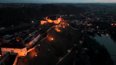 Burghausen Kalesi geceleri parlıyor, Woehrsee Gölü 'nden hava manzarası. Almanya 'nın Bavyera şehrinde yer alan bu bina Avrupa' nın en uzun kale kompleksi. Burg zu Burghausen oberhalb Altstadt Bayern, Deutschland 'da 
