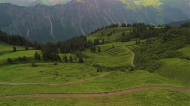 Alman Bavyera Alpleri 'nde Fellhorn ve Kanzelwand' ın çarpıcı alp manzarasının ortasında çakıllı yolda bisikletçi. Yeşil dağlarla, patikalarla ve nefes kesici panoramalarla dolu yaz macerasının havadan görüntüsü.. 