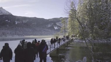 23 Aralık 2024. Almanya, Eibsee bei Grainau. Almanya 'nın Bavyera kentindeki Zugspitze yakınlarındaki donmuş Eibsee gölünün manzarası. Turistler dağlarla çevrili karlı köprüde toplandılar. Popüler fotoğraf noktası