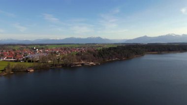 Eggstaett, Bavyera 'daki Hartsee ve St. Georg Kilisesi' nin insansız hava aracı videosu. Kristal berrak göl, manzara köyü, doğa koruma alanı ve huzurlu banyo, dinlenme yeri, Badestelle am Hartsee. Luftaufnahme