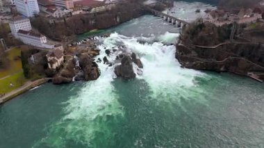 İsviçre 'de Neuhausen am Rheinfall ile Laufen-Uhwiesen arasında geçen Rheinfall' un insansız hava aracı görüntüleri. Bu hava videosu kükreyen suları, sisli çağlayanları ve çarpıcı doğal manzarayı yakalar.. 