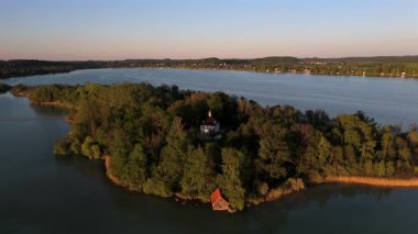 Mausinsel Gölü 'nün Bavyera, Almanya' daki hava günbatımı manzarası. Durgun sular ve doğal güzelliklerle çevrili küçük bir adada tarihi Woerth Kalesi ve St. Simpert Şapeli.
