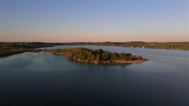 Luftaufnahme der Mausinsel im Woerthsee, Bayern, mit dem Schloss Woerth und der Kapelle St. Simpert. Umgeben von Natur, Wasser und malerischer Abendstimung. Luftbildansicht Fare Adası da buna değer.. 