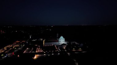 Fuerstenfeldbruck, Bavyera, Almanya 'daki Kloster Fuerstenfeld' in gece hava görüntüsü. Aydınlatılmış barok manastır kompleksi St. Maria kilisesi alacakaranlık gökyüzünün altında baş döndürücü bir manzarayla. 