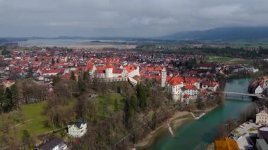 Almanya, Fuessen 'in nefes kesici hava manzarası, St. Mang Kilisesi, görkemli Hohes Schloss ve Lech Nehri' nin sergilenmesi. Büyüleyici ortaçağ kasabası yemyeşil ve Bavyera Alpleriyle çevrili.. 