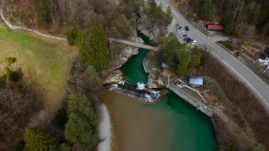 Lechfall, Fussen, Bavyera 'da çarpıcı bir şelale, yüksek açılı bir drone atışından yakalanmış. Manzaralı köprü, kristal berraklığında nehir ve resimli manzara onu mükemmel bir seyahat ve fotoğraf noktası yapıyor.