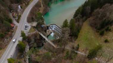 Lechfall, Fussen, Bavyera 'da çarpıcı bir şelale, yüksek açılı bir drone atışından yakalanmış. Manzaralı köprü, kristal berraklığında nehir ve resimli manzara onu mükemmel bir seyahat ve fotoğraf noktası yapıyor.