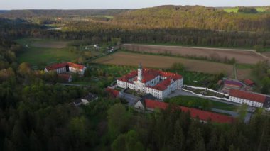 Güney Almanya 'daki Benedictine Kloster Schaeftlarn ve Praelatengarten parkının insansız hava aracı görüntüsü. Barok mimarisi, manikürlü bahçeler ve Isar Vadisi yakınlarındaki canlı bahar manzarası.. 