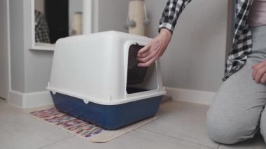 Olgun bir kadın kafası karışmış kedisine yeni bir çöp kutusuna girmesi için yardım etmeye çalışır. Kedi onu nazikçe cesaretlendirirken tereddüt ediyor, hatta ikna etmek için bir avro para koyuyor. Komik ve evcil hayvan anı. 