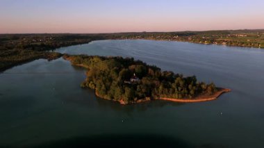 Havadan bakıldığında Mausinsel, Woerthsee 'deki Fare Adası, Bavyera, Almanya. Woerth Kalesi ve St. Simpert Şapeli. Huzurlu günbatımı sahnesinde su ve doğa ile çevrili. Luftbildansicht Worthsee