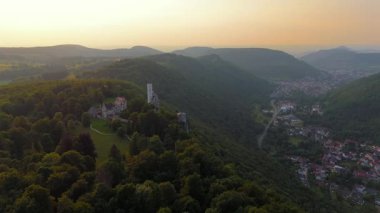 Sinema insansız hava aracı seyahat videosu Lichtenstein Kalesi, Baden-Wuerttemberg, Almanya. Yaz günbatımında parlayan bir dağ kalesi. Schloss Lichtenstein Wuerttemberg, Deutschland, Luftbild. 