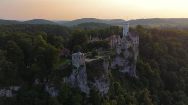 Drohnenflug bei altın saat. Schloss Lichtenstein hoch ueber dem Echaztal. Wahrzeichen in malerischer Naturkulisse im Landkreis Reutlingen in Baden-Wuerttemberg, Deutschland. 
