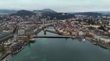 Drohnenaufnahme der Luzerner Altstadt mit Seebruecke, Reuss und Alpen im Hintergrund. Herbstliche Stimmung, Dunst ve See. Perfekt fuer Architektur und Naturdokumentationen. 