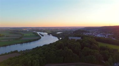 Walhalla bei Donaustauf im Sonnenuntergang. Luftaufnahme des klassizistischen Tempels auf dem Braeuberg bei Regensburg. Die Donau fliesst zu Fuessen, umgeben von goldener Abendstimmung. 