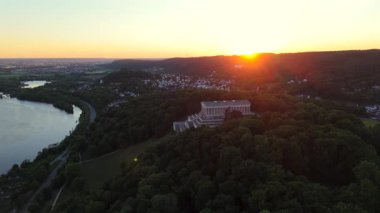 Almanya, Regensburg yakınlarındaki Braeuberg tepesindeki Walhalla anıtının günbatımı hava manzarası. Bu neoklasik tapınak Tuna Nehri 'ne bakıyor. Bavyera manzarası üzerinde altın saat ışığı parlıyor.. 