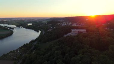 Walhalla bei Donaustauf im Sonnenuntergang. Luftaufnahme des klassizistischen Tempels auf dem Braeuberg bei Regensburg. Die Donau fliesst zu Fuessen, umgeben von goldener Abendstimmung. 